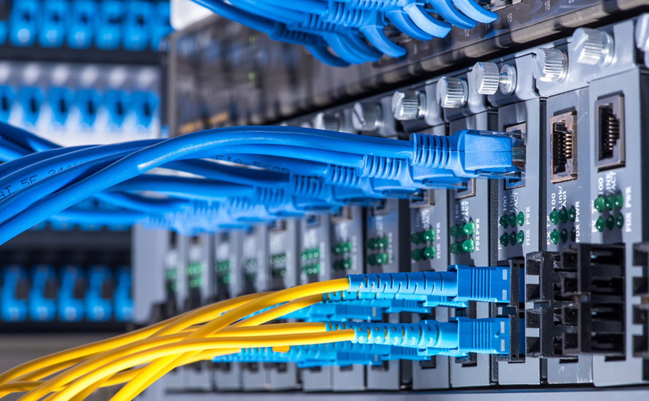 Nippon Labs Cat 6A UTP Ethernet Network Booted Cables are connected to devices stacked together
